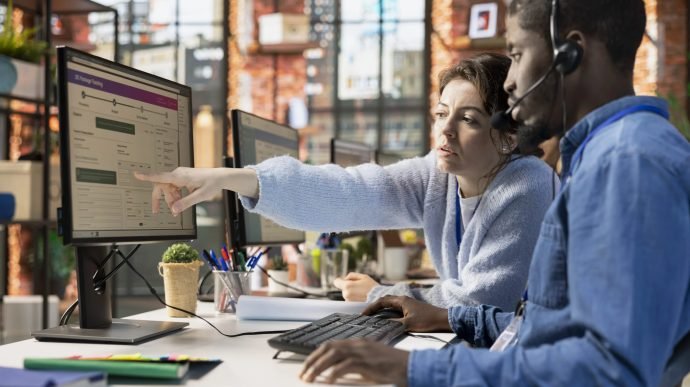 Call center agents collaborating to solve problem for customer, tracking lost shipments in office. Customer center colleagues working together using software to locate clients packages