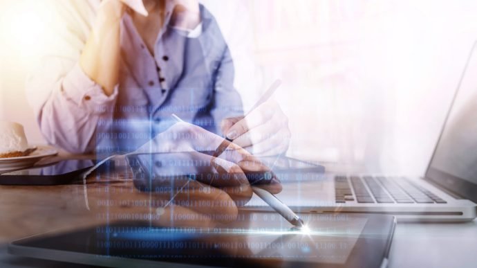 close up of businesswoman working with smart phone and laptop and digital tablet computer in modern office with virtual icon diagram